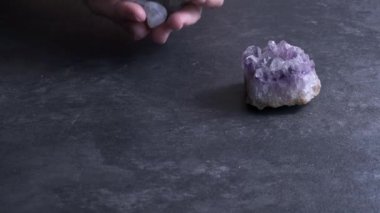 Siyah arka planda farklı değerli taşları olan bir erkek eli.