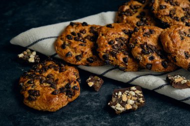 Koyu arkaplanda taze çikolatalı kurabiyeler.