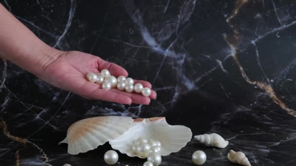 Perlen Schwappen Aus Einer Frauenhandfläche Eine Schale — Stockvideo
