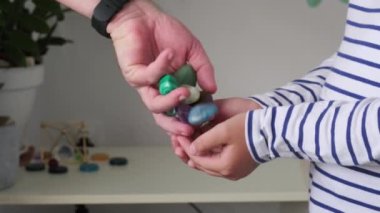 Küçük kızın avuçlarında farklı değerli taşlar var.