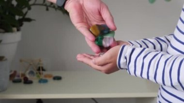 Küçük kızın avuçlarında farklı değerli taşlar var.