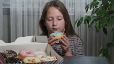 a blonde girl takes a donuts cake in her hands