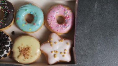 in the frame is a box with six different donuts