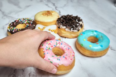 a wide variety of mouth-watering donuts on a white marble background