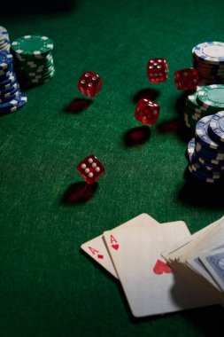 Poker için yeşil kumaş üzerinde birkaç kırmızı zar fişi.