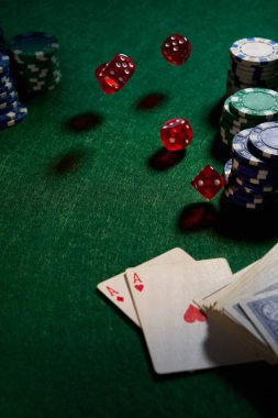 Poker için yeşil kumaş üzerinde birkaç kırmızı zar fişi.