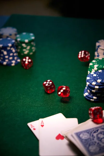 stock image a few red dice chips cards on green cloth for poker