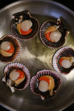 Lezzetli deniz tarakları kızartma tavasında pişirilir.