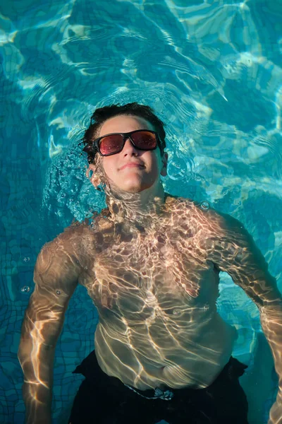 在游泳池里戴太阳镜的男孩的画像 — 图库照片