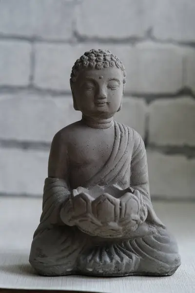 Una Piccola Statua Pietra Buddha Uno Sfondo Grigio Muro Mattoni — Foto Stock