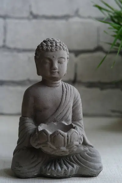 Una Piccola Statua Pietra Buddha Uno Sfondo Grigio Muro Mattoni — Foto Stock