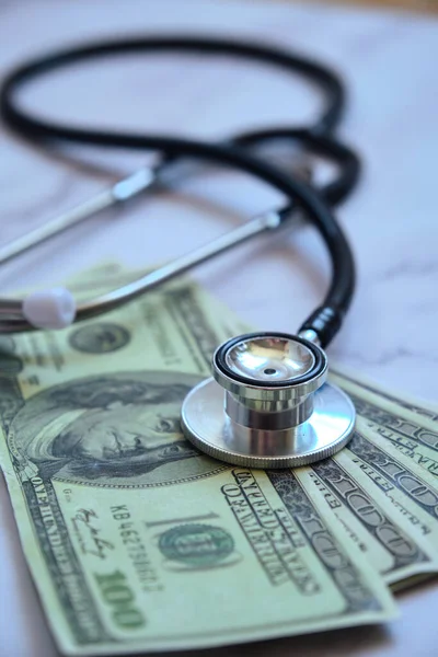a medical stethoscope and money several banknotes dollars on the table