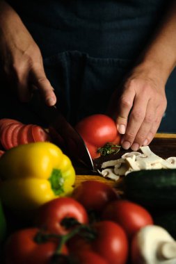 Domatesleri doğrayan, sebzeleri kesen aşçıların yakın çekimleri var.