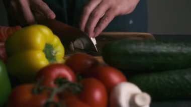 Sebzelerin etrafında şampiyonları doğrayan şeflerin elleri yavaş çekimde uzanır.