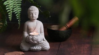 Duman tüten Palo Santo 'nun yanındaki karanlık arka planda Buda' nın taş heykeli.