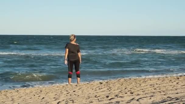 Kobieta Sportowym Ubraniu Spacerująca Plaży Wietrzny Dzień — Wideo stockowe