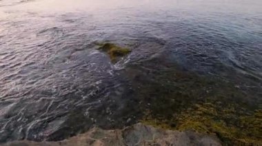 Akşam denizi sakin dalgalar kayalık kıyılarda yuvarlanır kayalık gölde