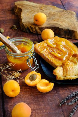 Kayısı ve tost, kayısı reçeli ahşap bir masada.