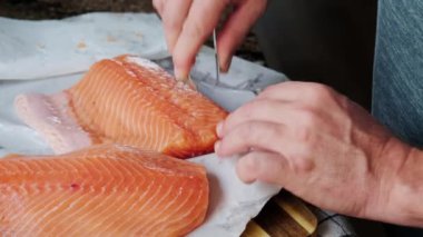 Erkekler somon fileto soyar ve keserler.