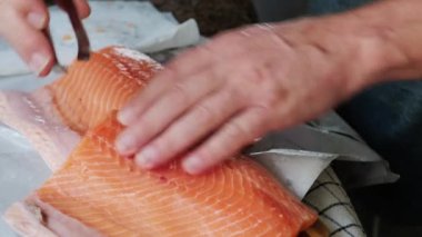 Erkekler somon fileto soyar ve keserler.