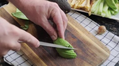 Olgun bir avokado kesme tahtasıyla kesilir.