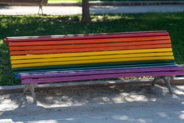 Şehir parkında LGBT renkleriyle boyanmış bir bank.