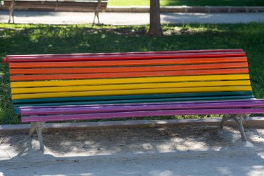 Şehir parkında LGBT renkleriyle boyanmış bir bank.