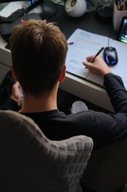 Genç bir çocuk evde ders alıyor.