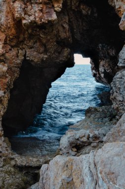 Doğal deniz taşından manzaralı mağara denizi ve günbatımı