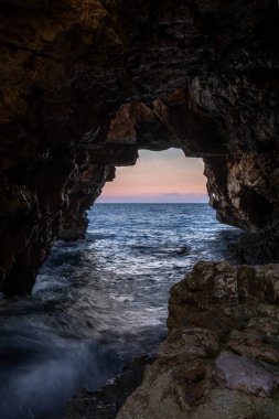 Doğal deniz taşından manzaralı mağara denizi ve günbatımı
