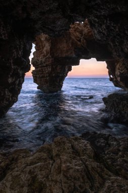 Doğal deniz taşından manzaralı mağara denizi ve günbatımı