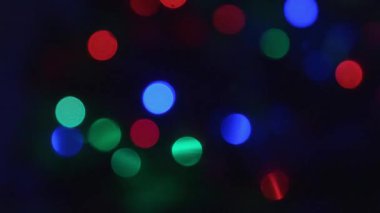 Renkli bulanık ışıklar koyu bir arkaplanda yanıp sönüyor