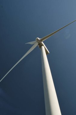 Arka planda mavi gökyüzü olan yakın plan rüzgar türbini