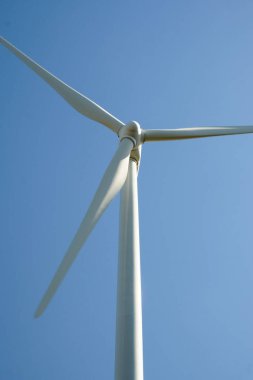 Arka planda mavi gökyüzü olan rüzgar türbini kapat