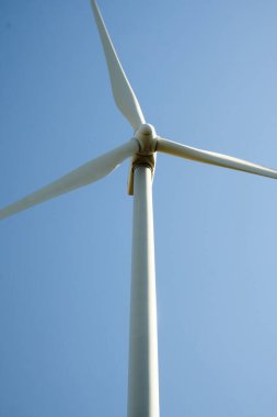 Arka planda mavi gökyüzü olan rüzgar türbini kapat