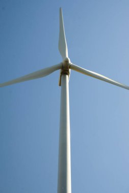 Arka planda mavi gökyüzü olan rüzgar türbini kapat