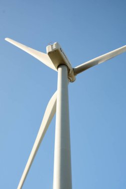 Arka planda mavi gökyüzü olan rüzgar türbini kapat
