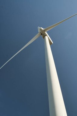 Arka planda mavi gökyüzü olan yakın plan rüzgar türbini