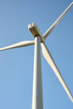 Arka planda mavi gökyüzü olan rüzgar türbini kapat