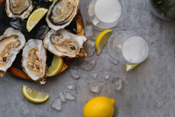 Limon dilimleri ve bir bardak şampanyayla tahtada istiridye aç.