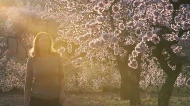 Badem çiçekleri eken ve aroma soluyan bir kadın.