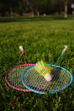 badminton raketleri ve yakın plan yeşil çimenler üzerinde mekik horozu