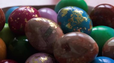 Renkli, parlak Paskalya yumurtaları tabağa yakın.