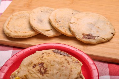 Geleneksel bir Orta Amerika yemeği olan Pupusas ile El Salvador 'un zengin lezzetlerinin tadını çıkarın. Köy ahşap bir tahtanın üzerinde curtido ve baharatlı sos ile servis edilir.