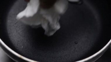 Yumurtaların bir tavada kırılıp kızardığı makro yakın çekim videosu, cızırtılı, altın sarısı ve lezzetli bir hazırlık.