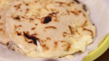 Curtido ve soslu pupusaların yakın plan fotoğrafı hazır yemek tepsisinde geleneksel bir plastik tabakta servis ediliyor..