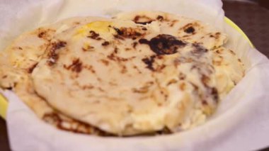 Curtido ve soslu pupusaların yakın plan fotoğrafı hazır yemek tepsisinde geleneksel bir plastik tabakta servis ediliyor..