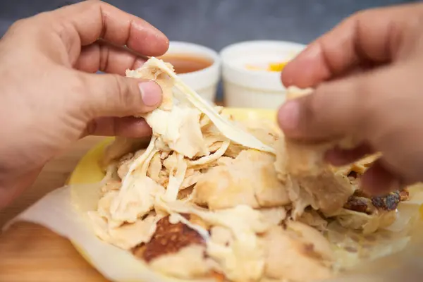 stock image Close-up of hands cutting open pupusas, revealing melted cheese strands, showcasing a delicious and traditional gourmet meal from central america, el salvador, honduras and guatemala