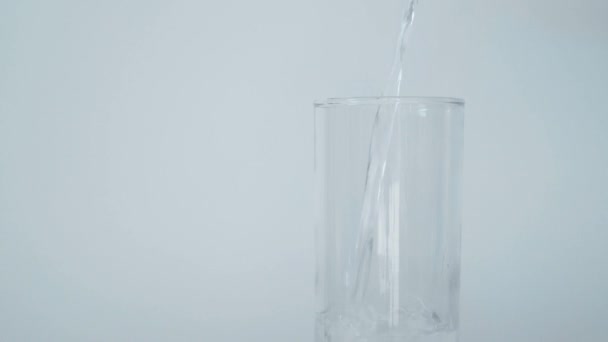 Наливание Очищенной Воды Стакан Воды Белом Фоне — стоковое видео