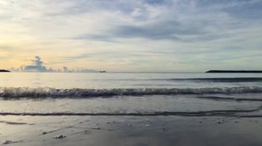 Sabahları deniz, güneş doğarken alçak dalgalarla